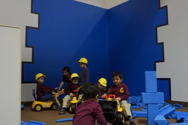 a group of people sitting at a desk in a small room
