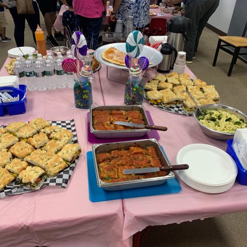 a group of people sitting at a table with a plate of food
