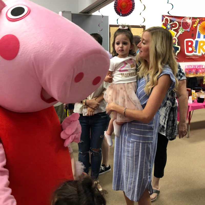 a little girl standing next to a person