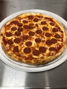 a pepperoni pizza sitting on top of a pan on a table